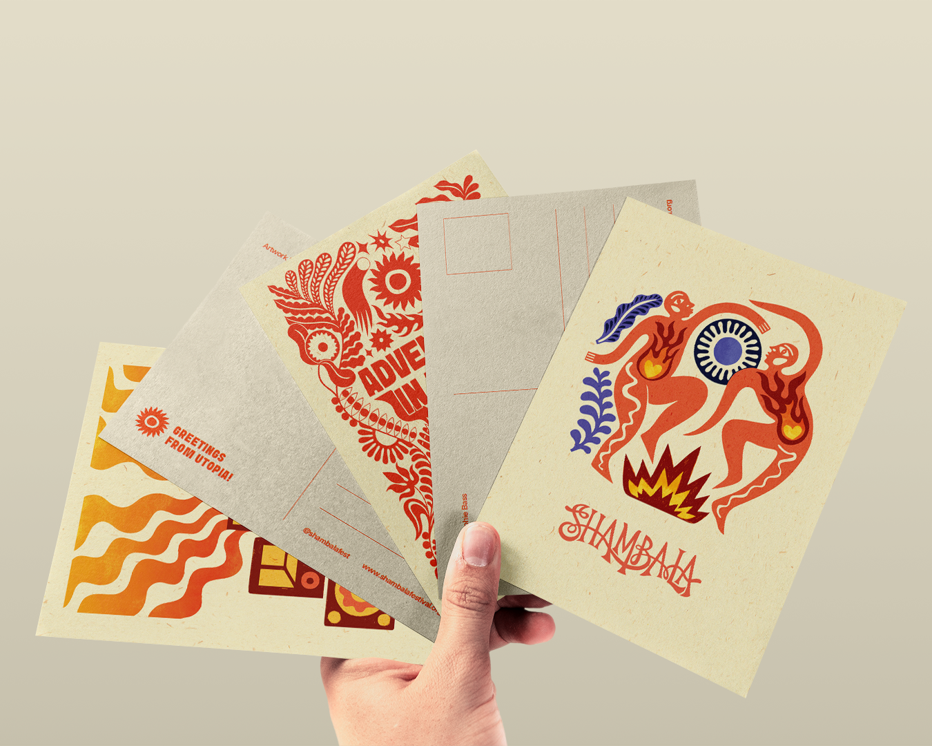 A hand displays five vibrant postcards from the POSTCARD SET: SHAMBALA x SOPHIE BASS, featuring bold abstract designs in orange, red, and blue with stylised human and animal figures.