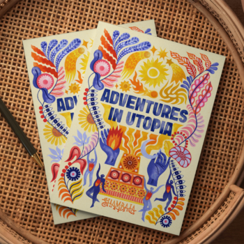 Two SHAMBALA 2026 PRINTED PROGRAMME booklets with vibrant, abstract floral and flame covers are placed on a woven round tray next to a black pen.