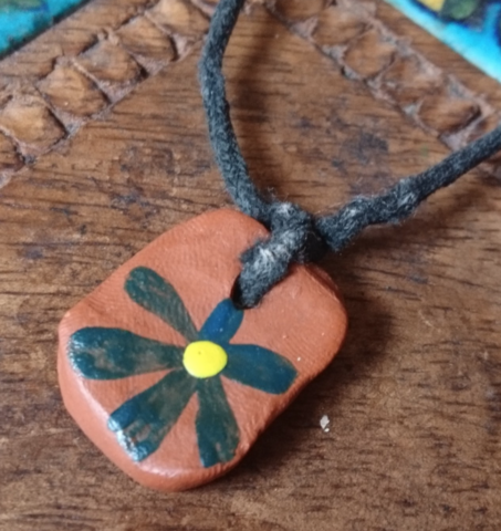 CAPTION – Before wristbands, we gave out clay pendants